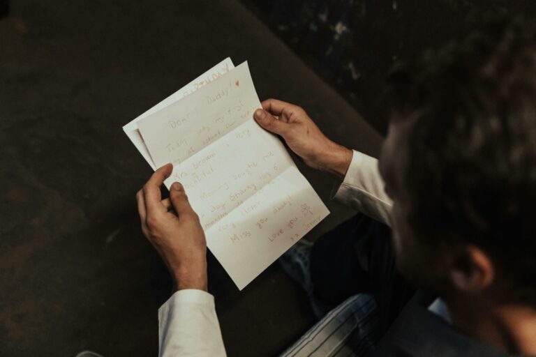 Un homme est assis à une table il lit une lettre dans un processus de reconquête.