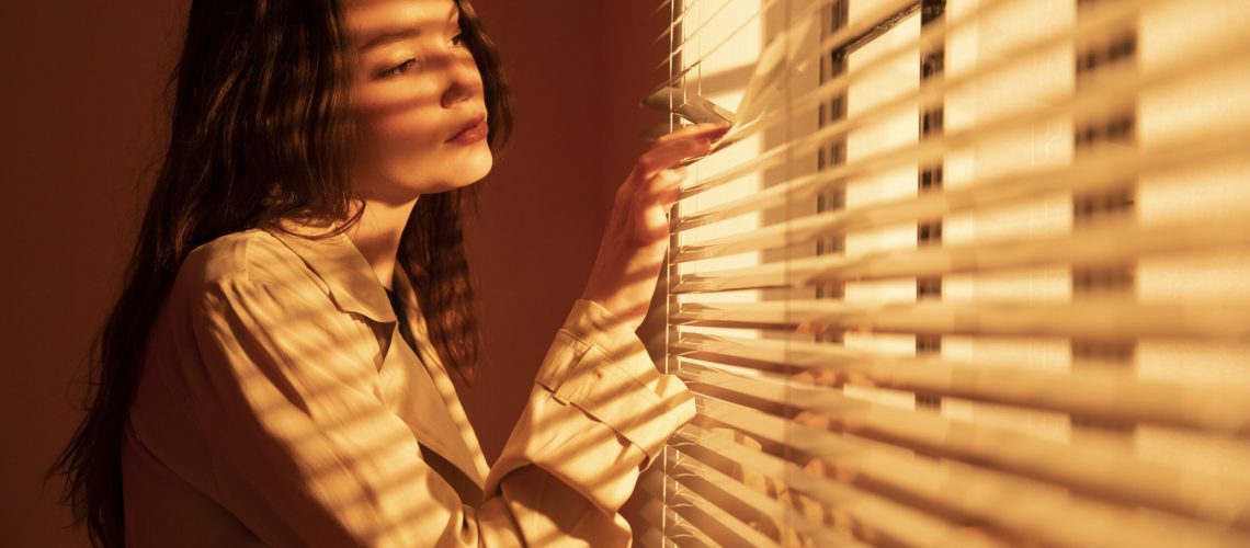 beautiful-young-woman-window-blinds